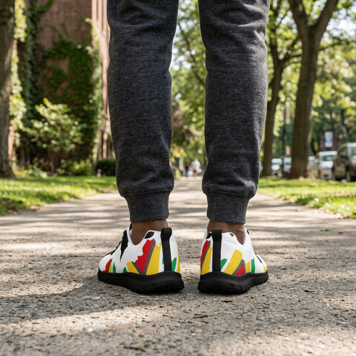 Colorful sneakers worn with dark gray pants on a white background