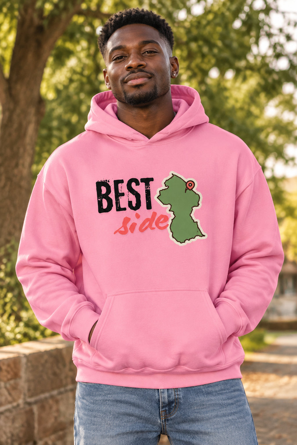 A pink pullover hoodie with a front graphic that reads 'BEST Side' in black and coral-red lettering, alongside a green Guyana map shape with a red pin icon. The hoodie is shown on a plain white background.