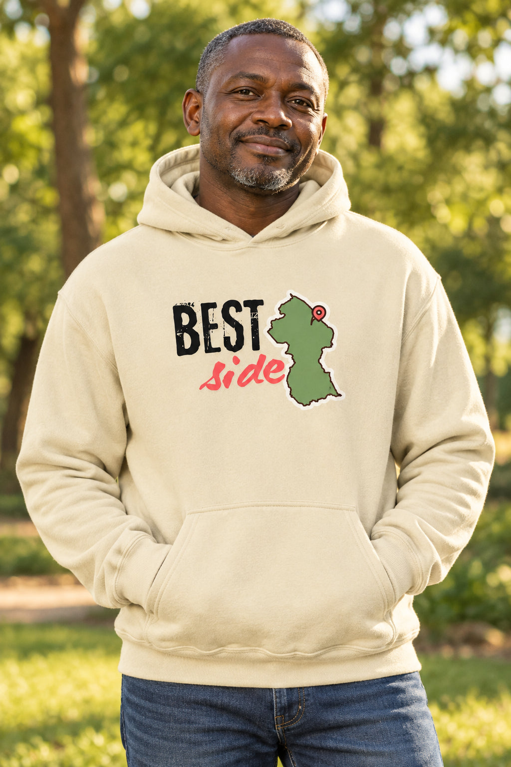 A beige pullover hoodie with a graphic on the chest that reads 'BEST Side' in black and pink text, alongside a green Guyana map outline with a red pin icon, shown on a plain white background.