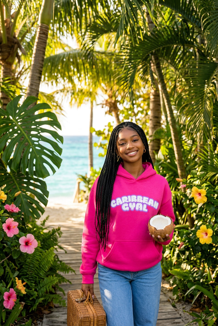 A bright pink pullover hoodie with a front kangaroo pocket and a graphic text print reading 'CARIBBEAN GYAL' in white bubble letters with a light blue outline, shown on a plain white background.
