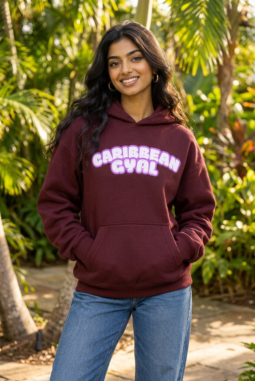A maroon pullover hoodie with a front kangaroo pocket and a hood, featuring the words 'CARIBBEAN GYAL' printed across the chest in a stylized pink and white bubble font, shown against a plain white background.
