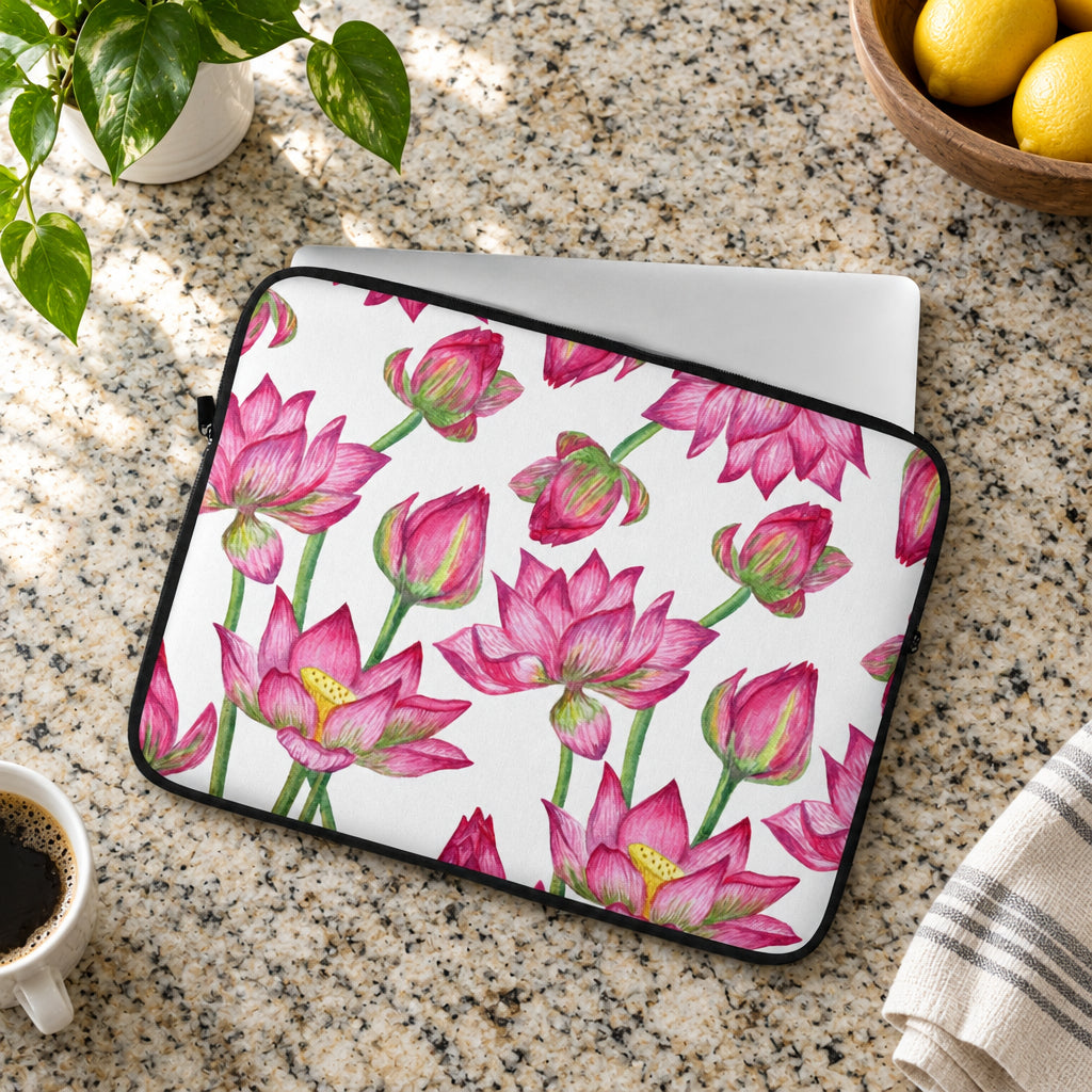 Laptop sleeve with pink lotus flower pattern on a light gray surface with green leaves.