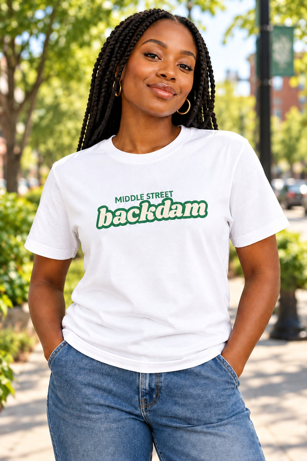 A white short-sleeve crewneck t-shirt featuring a green graphic print on the chest that reads 'MIDDLE STREET backdam' in a retro font.