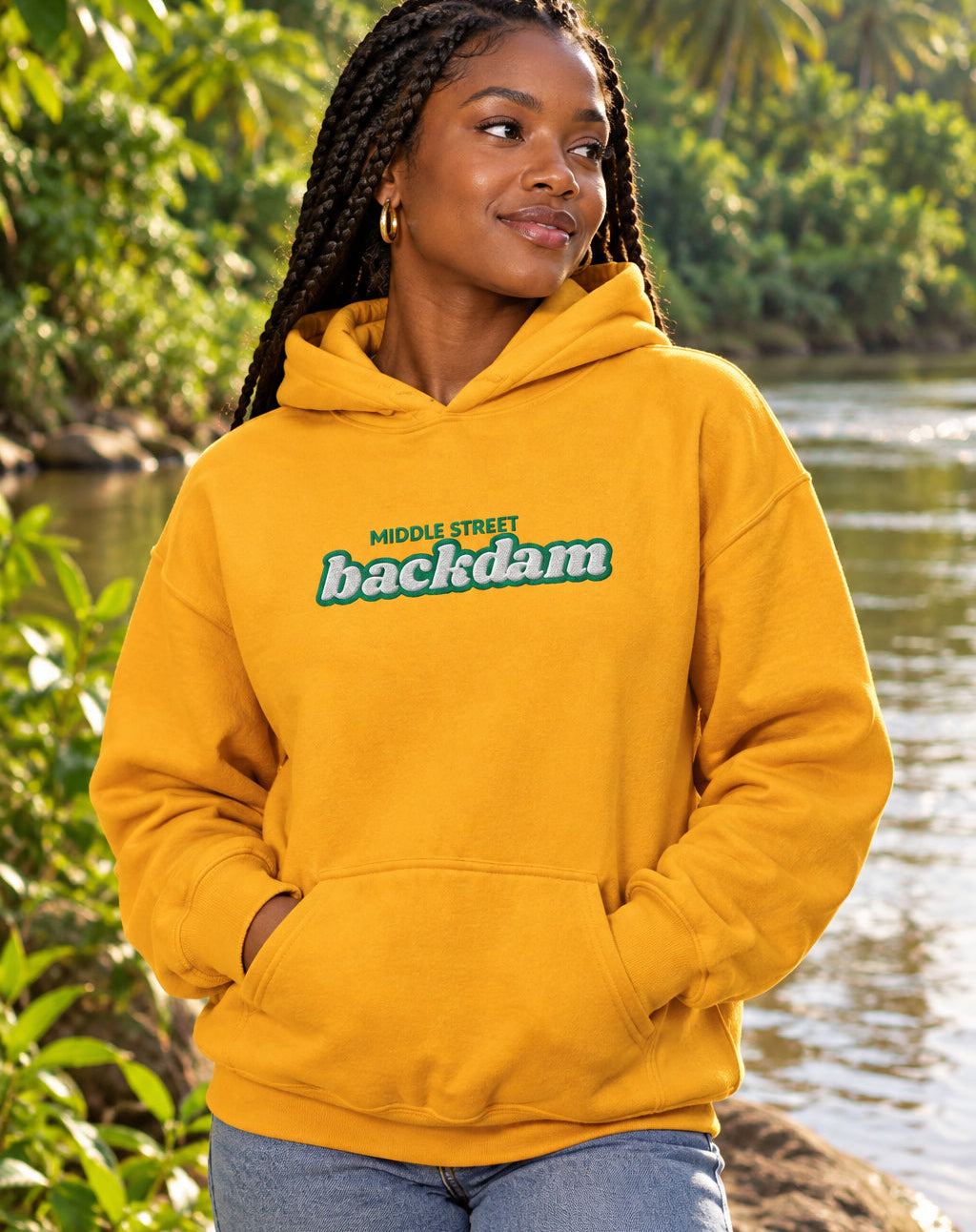 A bright yellow pullover hoodie with a front kangaroo pocket and a chest graphic reading 'MIDDLE STREET backdam' in green and blue, shown on a plain white background.