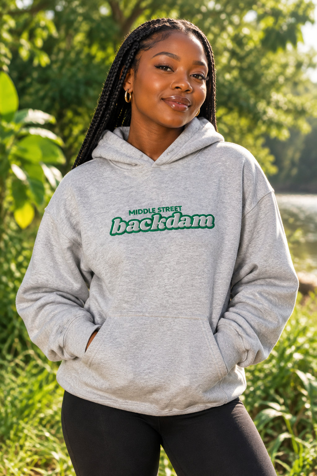 A light heather gray pullover hoodie with a front kangaroo pocket and a green graphic text print reading 'MIDDLE STREET backdam' across the chest, shown on a plain white background.