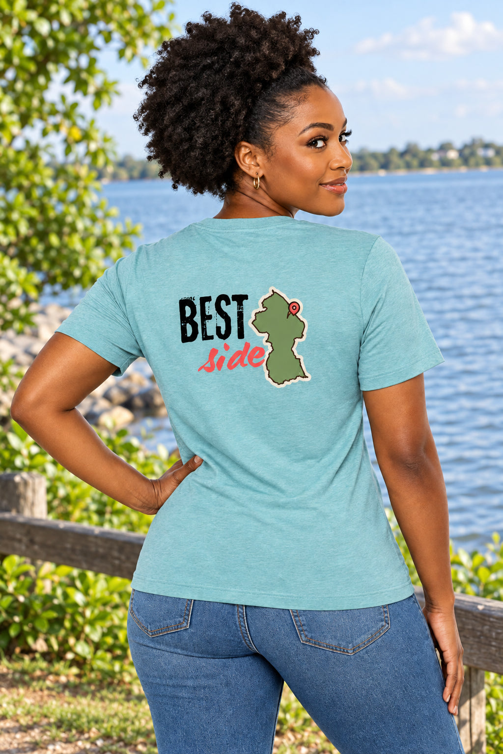 A light blue short-sleeve t-shirt shown from the back, featuring a graphic print with the text 'BEST Side' and an olive green map outline of Guyana with a red pin.
