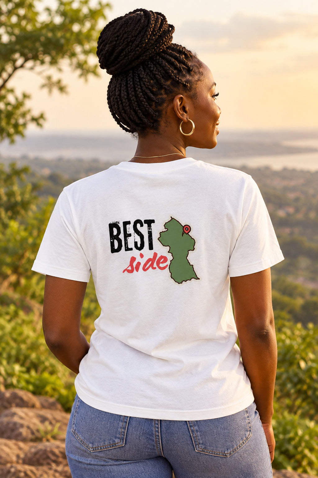 An off-white short-sleeve t-shirt shown from the back, featuring a graphic print with the text 'BEST Side' and a green silhouette Guyana map with a red pin.