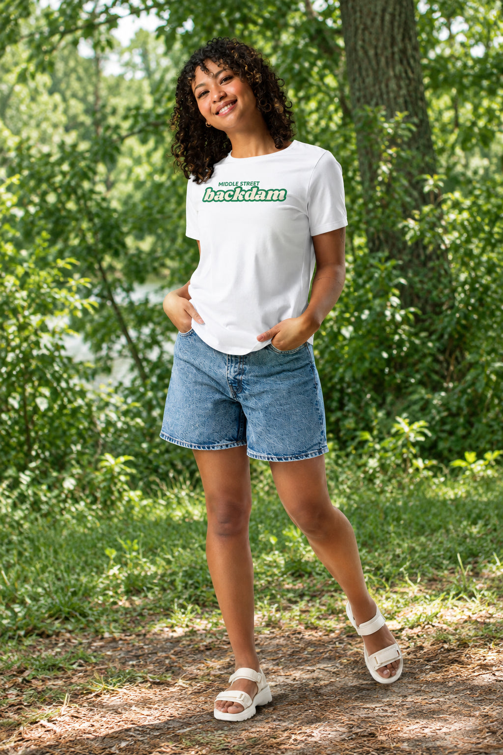Woman wearing a white t-shirt with text and graphics, paired with denim shorts on a white background