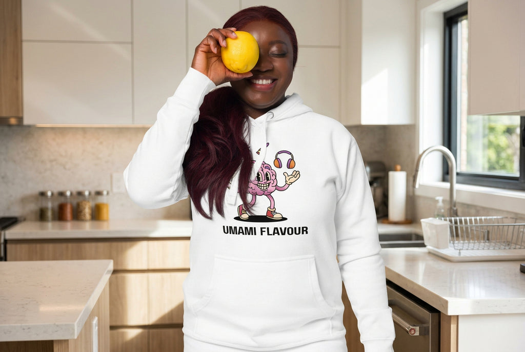 Person wearing a white hoodie with a cartoon character and 'UMAMI FLAVOUR' text, holding a lemon