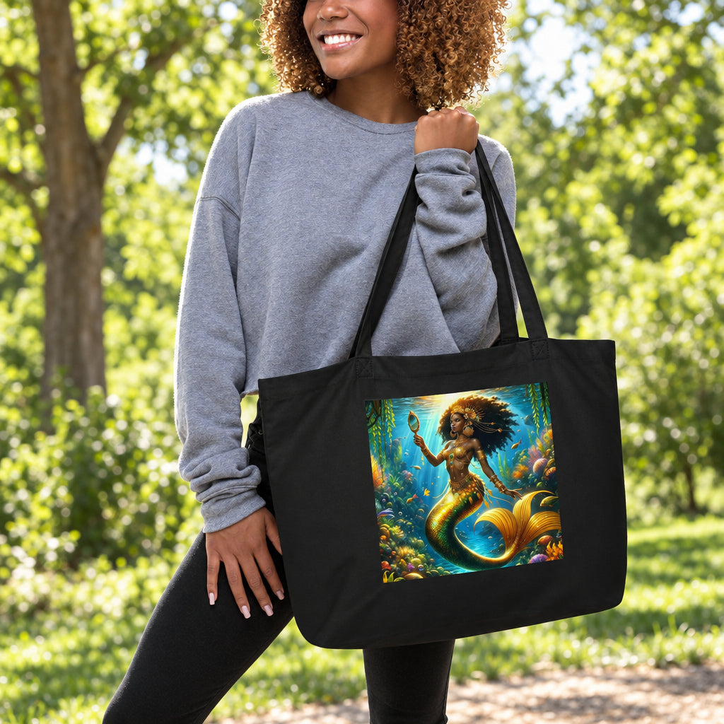 Woman holding a black Wata Mumma tote bag with a mermaid design on a white background